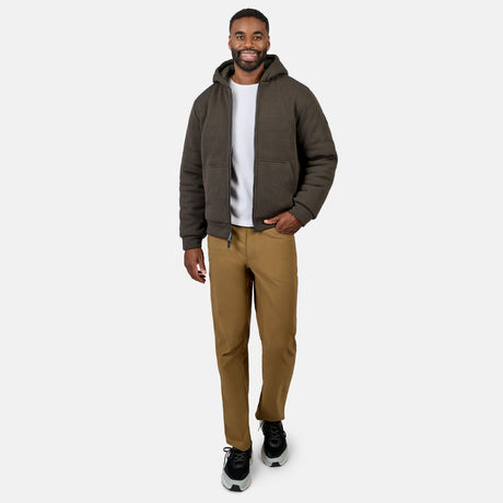 Model wearing men's Chayote Cable Fleece Reversible Jacket in dark taupe with hood and zip front