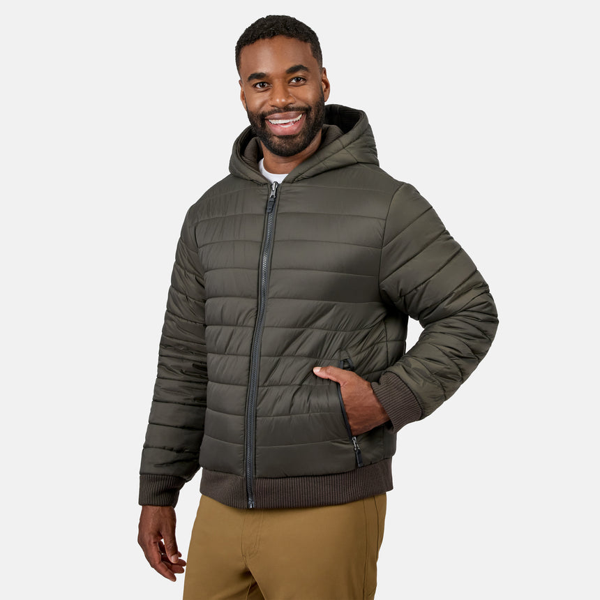 Man wearing olive green Chayote fleece reversible jacket with hood, zipped up and smiling.