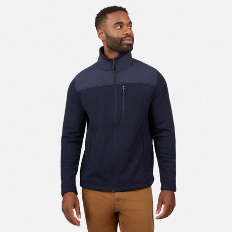 [Model is wearing size M.] A man wearing a navy blue quarter-zip fleece jacket with a contrasting dark gray shoulder yoke, paired with tan pants, against a light gray studio background.