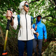 Two hikers in outdoor gear walking through a forest