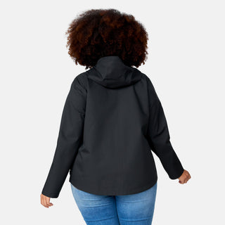 A woman with curly hair wears the Free Country Women's Plus Size X2O Packable Rain Jacket in black and blue jeans, shown from the back against a plain light background.