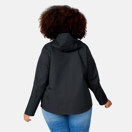 A woman with curly hair wears the Free Country Women's Plus Size X2O Packable Rain Jacket in black and blue jeans, shown from the back against a plain light background.