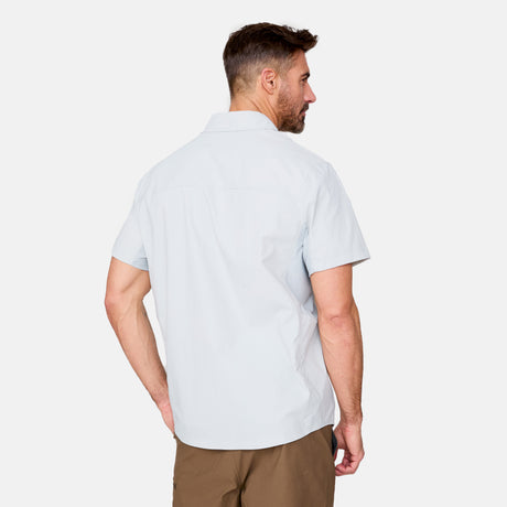 [Justin is 6'1" wearing a size Medium.] Man wearing the Free Country Men's Acadia Short Sleeve Shirt in fog, size M, featuring a short sleeves, mesh underarm panels for breathability, and a zipper chest pocket made from lightweight polyester fabric, styled with khaki shorts #color_ fog