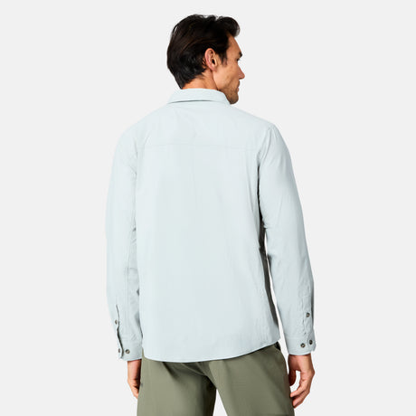 A man is shown from the back wearing a light gray Free Country Men's Acadia Long Sleeve Shirt and olive green pants against a plain white background.