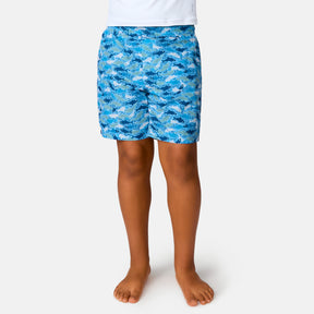 [Model is wearing a size Medium.] Boy wearing the Free Country Boys' Reel Catch Swim Short in Wave Reel Catch, size M, featuring recycled polyester fabric and elastic waistband and upf protection, paired with white sunshirt #color_ wave-reel-catch