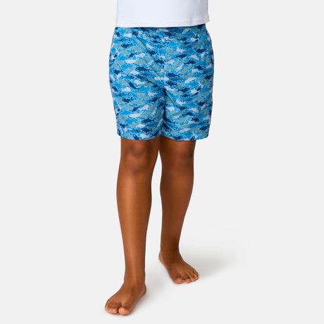 [Model is wearing a size Medium.] Boy wearing the Free Country Boys' Reel Catch Swim Short in Wave Reel Catch, size M, featuring recycled polyester fabric and elastic waistband and upf protection, paired with white sunshirt #color_ wave-reel-catch