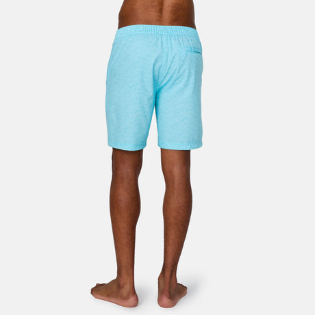 [Anderson is 6'2" wearing a size Medium.] Man wearing Free Country Men's Textured Surf Swim Short in Aqua, size M, made from moisture wicking stretch performance fabric featuring  a half back elastic waistband and fly front drawstring front closure #color_aqua
