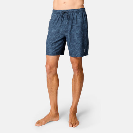 [Model is wearing size M] Person wearing blue patterned shorts on a white background