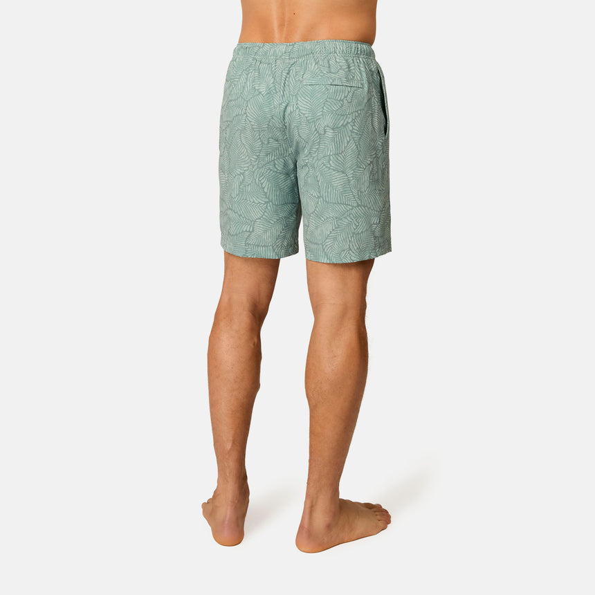 [Model is wearing size M] Person wearing green patterned shorts on a white background