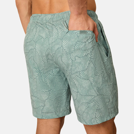 [Model is wearing size M] Green leaf-patterned shorts worn by a person on a light gray background