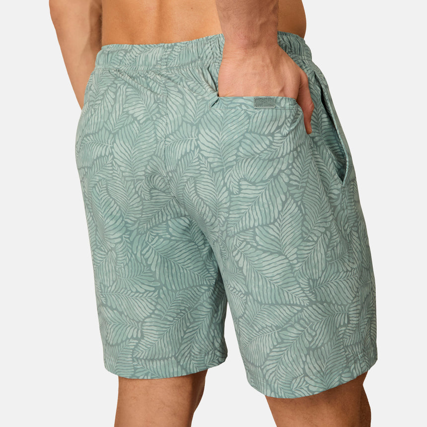 [Model is wearing size M] Green leaf-patterned shorts worn by a person on a light gray background