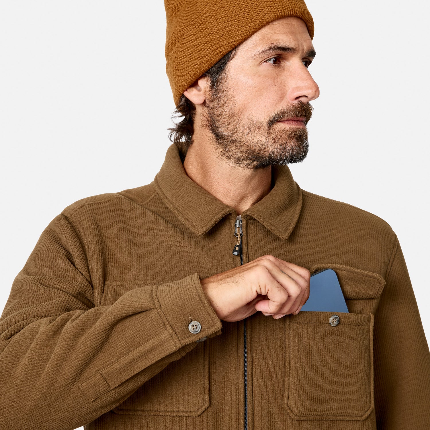 [Model is wearing size M.] A man wearing a brown corduroy jacket and a matching brown beanie, shown in a close-up profile view against a light gray background.