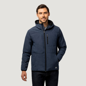 A man with short brown hair and a trimmed beard smiles slightly while wearing the Clearance Men's Melange Stretch Full Zip Hoodie, which is dark blue, wind and water resistant, with a front zipper and chest pocket, against a plain light gray background.