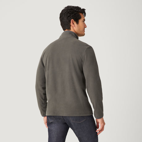 A man with short dark hair is seen from behind in the Clearance Men's FreeCycle® Super Soft Microfleece 1/2 Zip Mock Neck Shirt and dark jeans, standing against a plain white background.