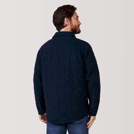 A man with short brown hair and a beard faces away from the camera, wearing the Clearance Men's Super Soft Microfleece Shirt Jacket in navy blue and blue jeans against a plain light background.