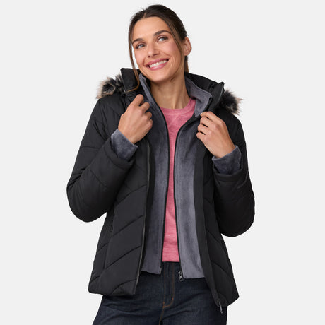 [Olga is 5’9" wearing a size Small.] Woman wearing Free Country Women's Brisk II Parka Jacket in black with a full front zipper opening, soft lining, attached hood with faux fur trim, recycled polyester fill, and water resistant and wind resistant stretch performance fabric, light grey background. Perfect women’s  jacket for fall weather.