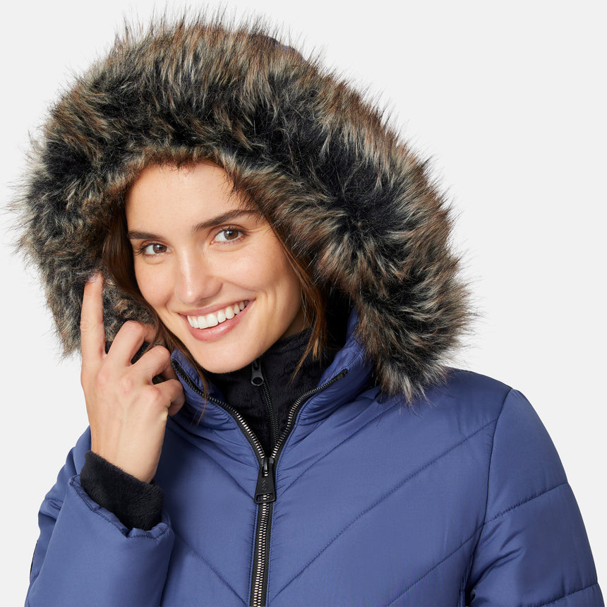 [Jessica is 5'9.5" wearing size S.] Woman wearing a blue puffer jacket with a fur-lined hood on a white background