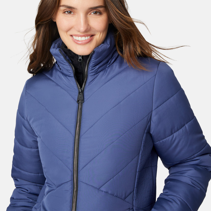 [Jessica is 5'9.5" wearing size S.] Woman wearing a blue puffer jacket with a fur-lined hood on a white background
