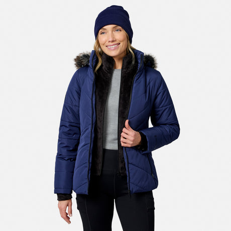 A woman wearing a navy blue Women’s Brisk II Parka Jacket with a faux-fur trimmed hood and a matching beanie.