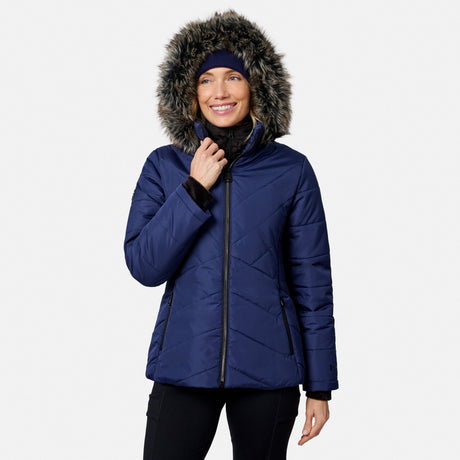 A woman wearing a navy blue quilted Women’s Brisk II Parka Jacket with a faux fur-trimmed hood.