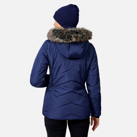 A person seen from behind wearing a blue Free Country Women’s Brisk II Parka Jacket with a faux-fur trimmed hood and a matching beanie.