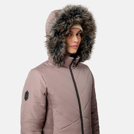 Woman wearing a mauve quilted Women’s Brisk II Parka Jacket by Free Country with a faux fur-lined hood.