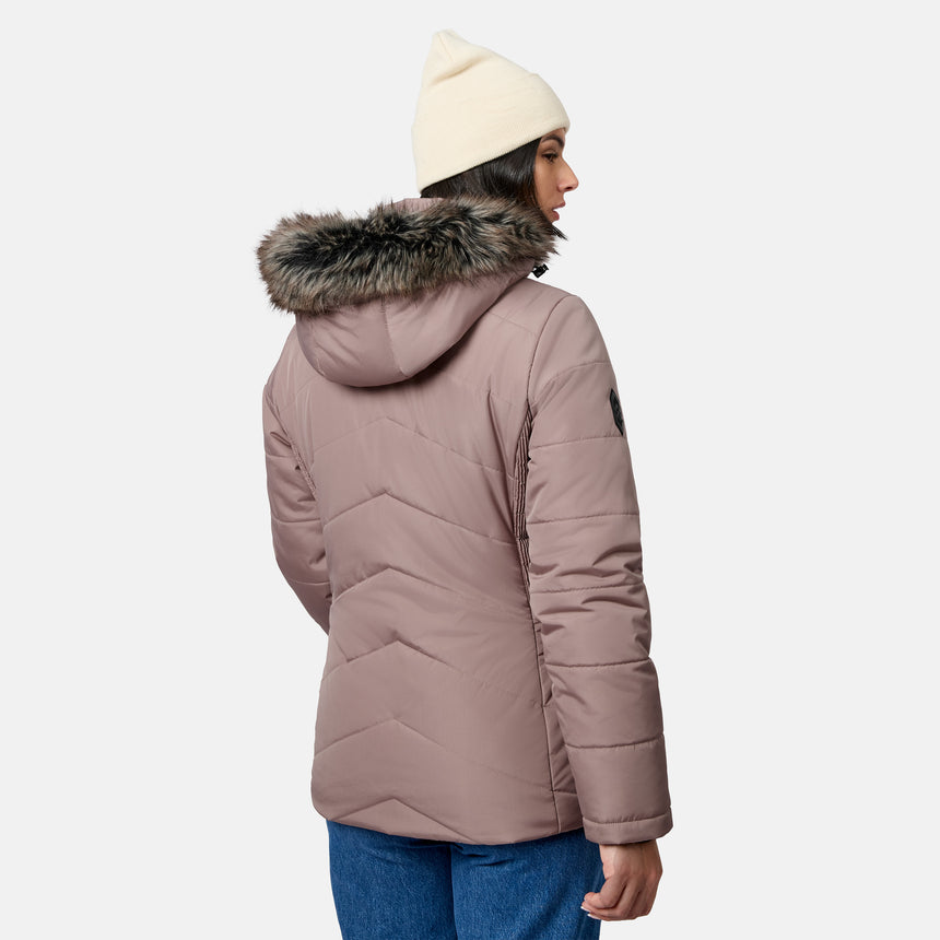 A woman seen from behind, wearing a mauve Free Country Women’s Brisk II Parka Jacket with a faux-fur trim hood and a cream beanie.
