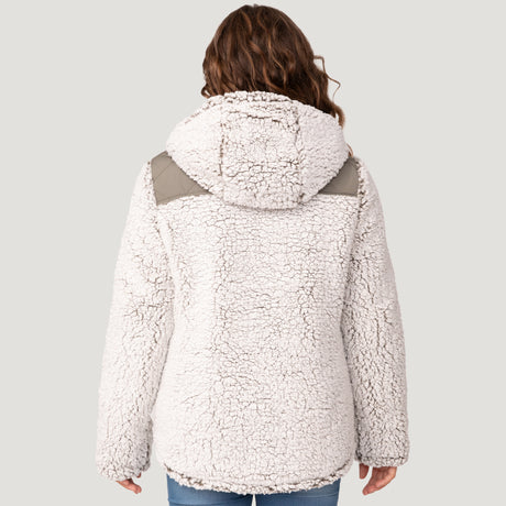 [Model is wearing a size Medium.] Girl wearing the Free Country Girls' Stratus Lite Reversible Jacket in grey, featuring a diamond quilted pattern and a sherpa lining with a plain yolk, standing and smiling with hands in pockets against a plain backdrop.