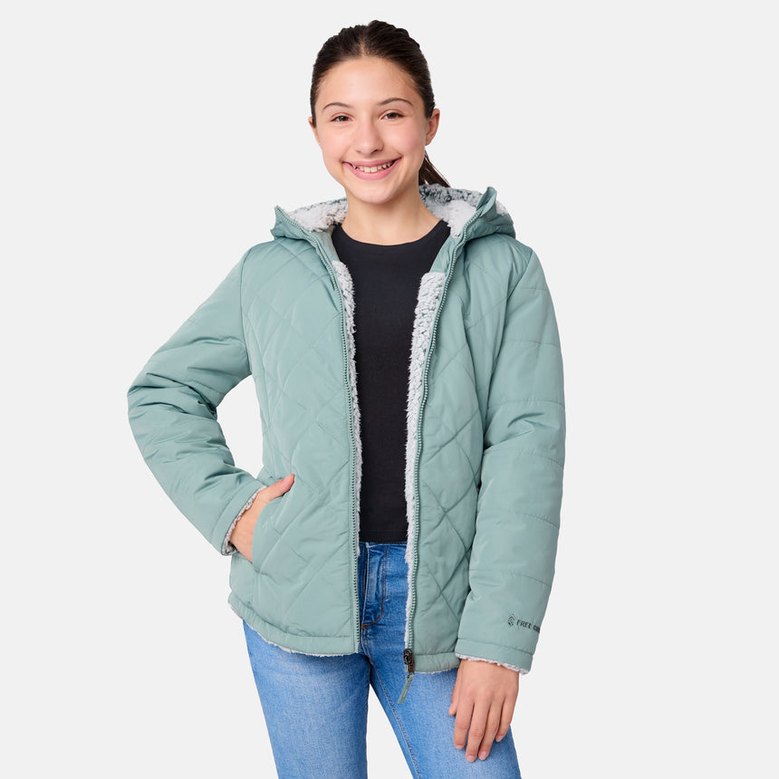 [Samantha is wearing size M] Model wearing a quilted light green Free Country hooded jacket with plush interior lining and full front zip; styled with denim for a relaxed, outdoors-ready look.