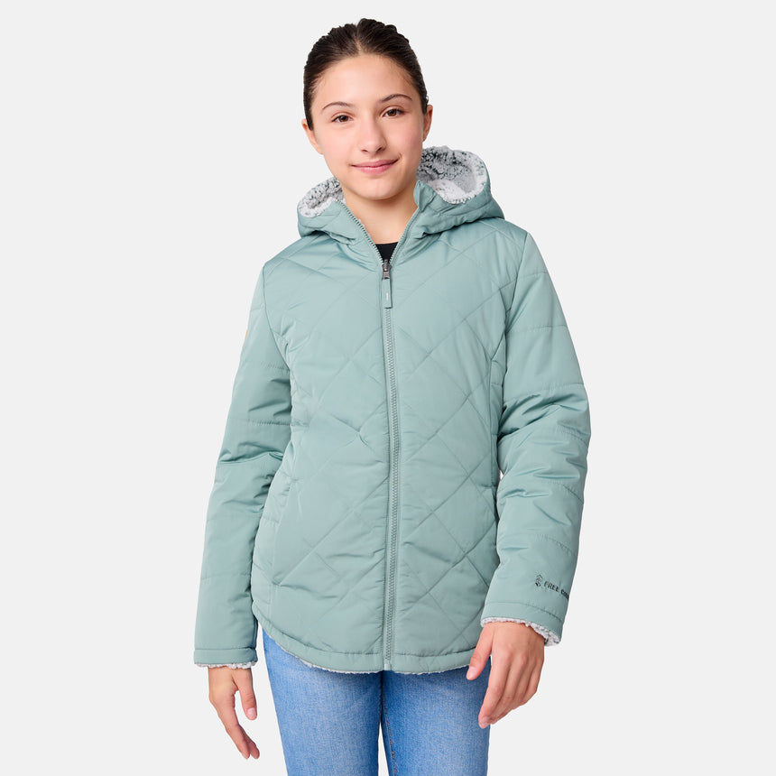 [Samantha is wearing size M] Model wearing a quilted light green Free Country hooded jacket with plush interior lining and full front zip; styled with denim for a relaxed, outdoors-ready look.