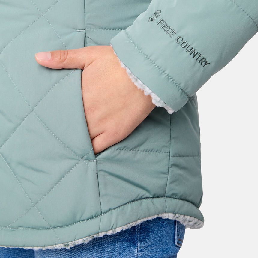 [Samantha is wearing size M] Model wearing a quilted light green Free Country hooded jacket with plush interior lining and full front zip; styled with denim for a relaxed, outdoors-ready look.