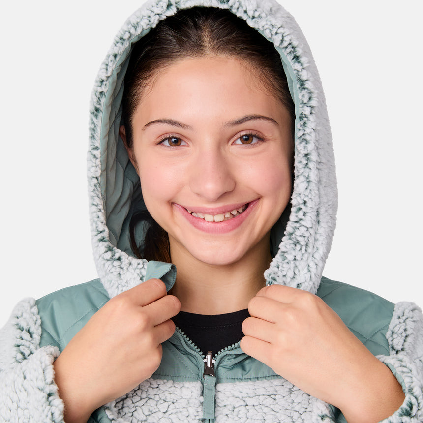 [Samantha is wearing size M] Model wearing a quilted light green Free Country hooded jacket with plush interior lining and full front zip; styled with denim for a relaxed, outdoors-ready look.