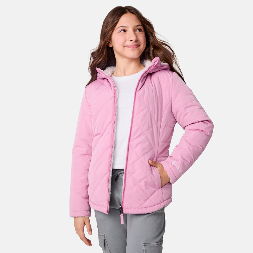 [Samantha is wearing size M] Model wearing a quilted light pink Free Country hooded jacket with diagonal stitching and soft interior lining; casually styled with gray utility pants and a white tee for a laid-back, trail-to-town vibe.