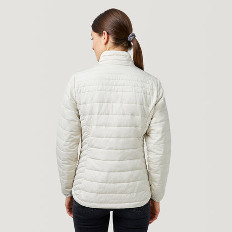 A woman with brown hair in a ponytail wears the Clearance Women's FreeCycle® Lansby Packable Puffer Jacket and dark pants, standing with her back to the camera against a plain light background.