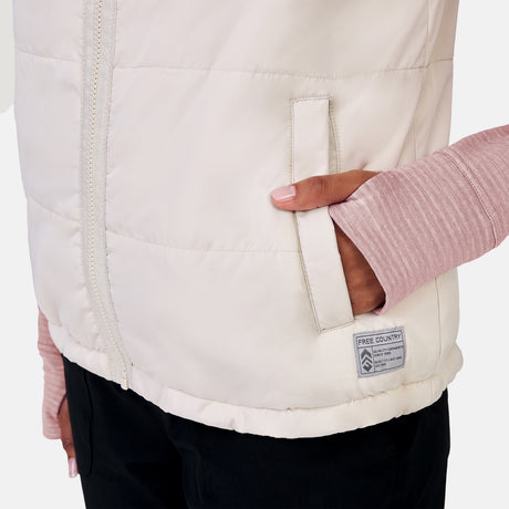 [Alexis is 5’6” wearing a size Small.] Woman wearing the Free Country Women's Venture Stratus Lite Reversible Vest in light gray, featuring a geometric-print Butter Pile® lining and horizontal quilted overlay