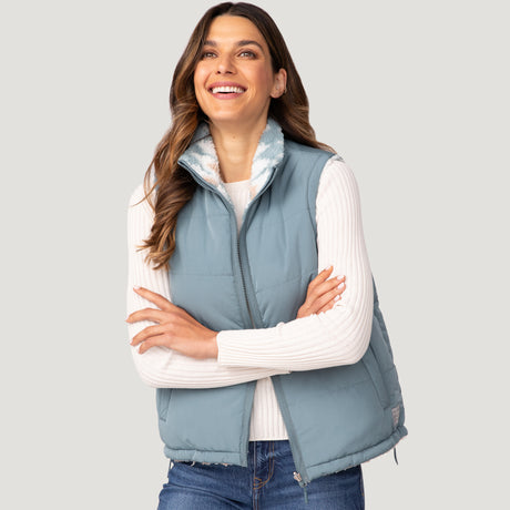[Olga is 5’9" wearing a size Small.] Woman wearing the Free Country Women's Venture Stratus Lite Reversible Vest in light blue, featuring a geometric-print Butter Pile® lining and horizontal quilted overlay