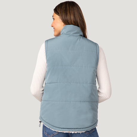 [Olga is 5’9" wearing a size Small.] Woman wearing the Free Country Women's Venture Stratus Lite Reversible Vest in light blue, featuring a geometric-print Butter Pile® lining and horizontal quilted overlay