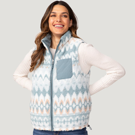 [Olga is 5’9" wearing a size Small.] Woman wearing the Free Country Women's Venture Stratus Lite Reversible Vest in light blue, featuring a geometric-print Butter Pile® lining and horizontal quilted overlay