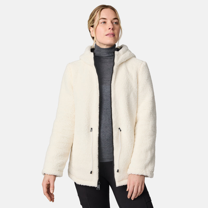 [CJ is 5'10" wearing size S.] Woman wearing Free Country Women's Switch It Up Cloud Lite Reversible Jacket in black with a full front zipper opening, attached hood with adjustable drawcord, diamond quilting, soft lining, and water resistant and wind resistant stretch performance fabric. light grey background. Perfect women’s  jacket for fall weather.