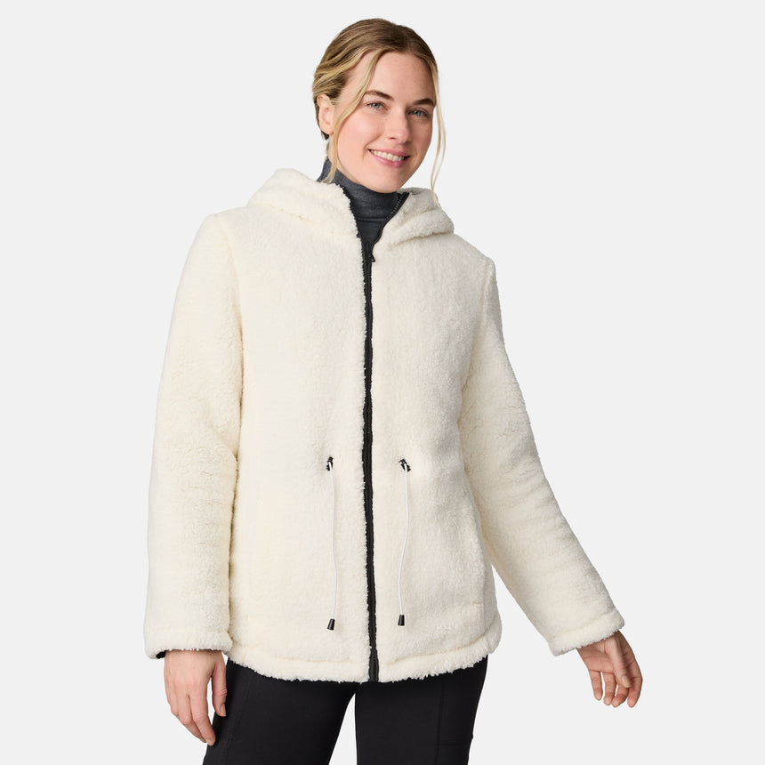 [CJ is 5'10" wearing size S.] Woman wearing Free Country Women's Switch It Up Cloud Lite Reversible Jacket in black with a full front zipper opening, attached hood with adjustable drawcord, diamond quilting, soft lining, and water resistant and wind resistant stretch performance fabric. light grey background. Perfect women’s  jacket for fall weather.