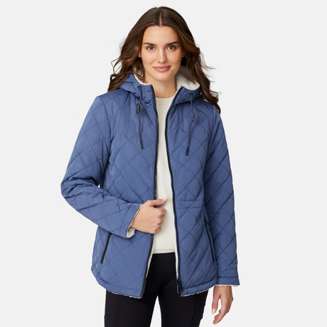[Jessica is 5'9.5" wearing size S.] Model wearing blue quilted jacket with hood and black pants — reversible design with cream pile interior for cozy, cold-weather layering