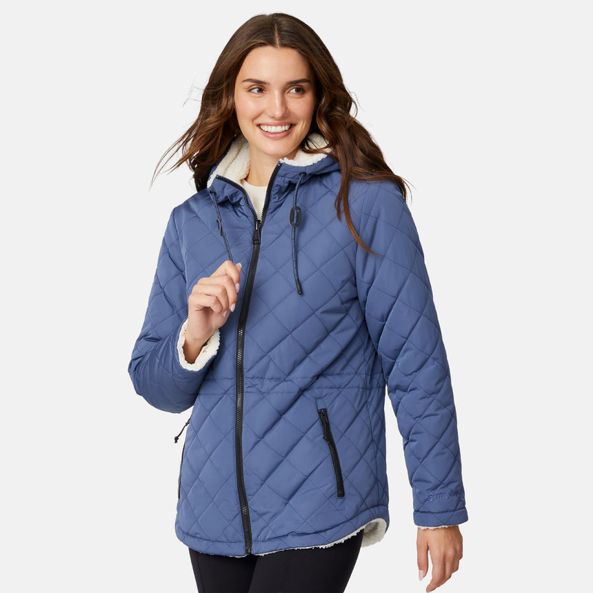 [Jessica is 5'9.5" wearing size S.] Model wearing blue quilted jacket with hood and black pants — reversible design with cream pile interior for cozy, cold-weather layering