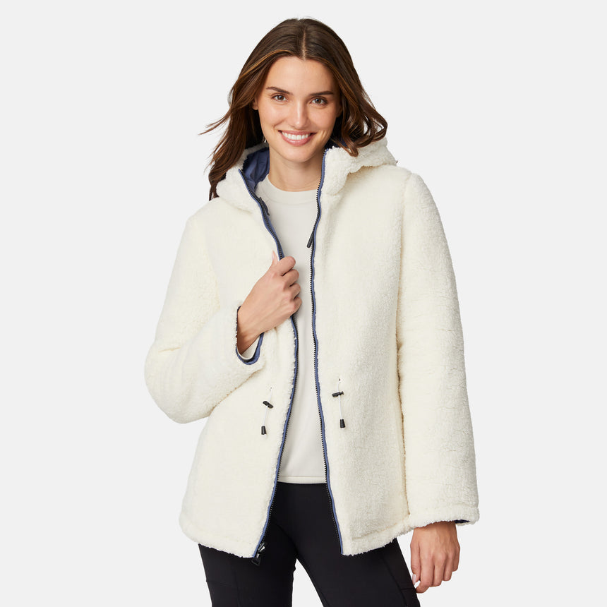 [Jessica is 5'9.5" wearing size S.] Model wearing blue quilted jacket with hood and black pants — reversible design with cream pile interior for cozy, cold-weather layering