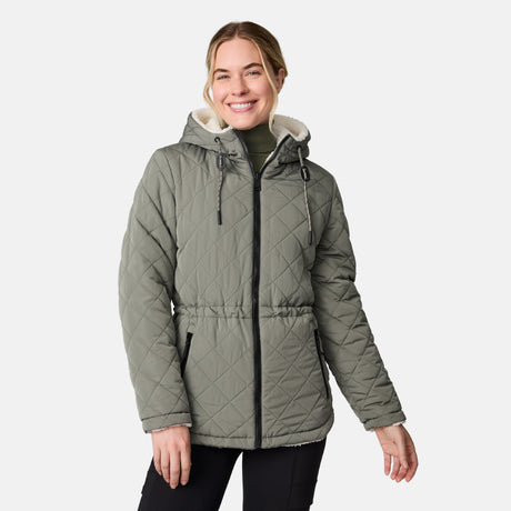 [CJ is 5'10" wearing size S.] Woman wearing Free Country Women's Switch It Up Cloud Lite Reversible Jacket in green with a full front zipper opening, attached hood with adjustable drawcord, diamond quilting, soft lining, and water resistant and wind resistant stretch performance fabric. light grey background. Perfect women’s  jacket for fall weather.