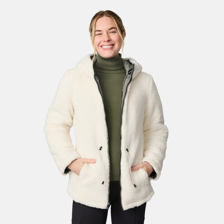 [CJ is 5'10" wearing size S.] Woman wearing Free Country Women's Switch It Up Cloud Lite Reversible Jacket in green with a full front zipper opening, attached hood with adjustable drawcord, diamond quilting, soft lining, and water resistant and wind resistant stretch performance fabric. light grey background. Perfect women’s  jacket for fall weather.