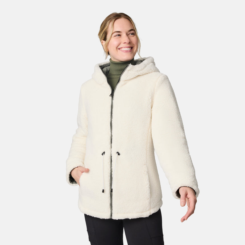 [CJ is 5'10" wearing size S.] Woman wearing Free Country Women's Switch It Up Cloud Lite Reversible Jacket in green with a full front zipper opening, attached hood with adjustable drawcord, diamond quilting, soft lining, and water resistant and wind resistant stretch performance fabric. light grey background. Perfect women’s  jacket for fall weather.