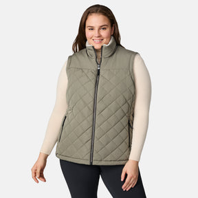 [Karissa is 5'9.5" wearing size 1X.]  Women’s Free Country light green diamond-quilted vest with zip-front closure and zippered pockets—reverses to cozy sherpa for added warmth and texture. Styled over a light long-sleeve shirt and dark pants for a versatile, cold-weather look.
