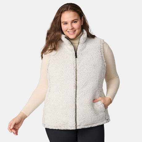 [Karissa is 5'9.5" wearing size 1X.]  Women’s Free Country light green diamond-quilted vest with zip-front closure and zippered pockets—reverses to cozy sherpa for added warmth and texture. Styled over a light long-sleeve shirt and dark pants for a versatile, cold-weather look.