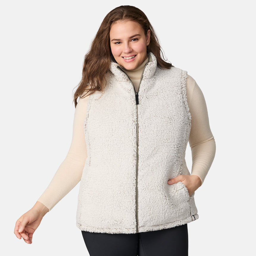 [Karissa is 5'9.5" wearing size 1X.]  Women’s Free Country light green diamond-quilted vest with zip-front closure and zippered pockets—reverses to cozy sherpa for added warmth and texture. Styled over a light long-sleeve shirt and dark pants for a versatile, cold-weather look.