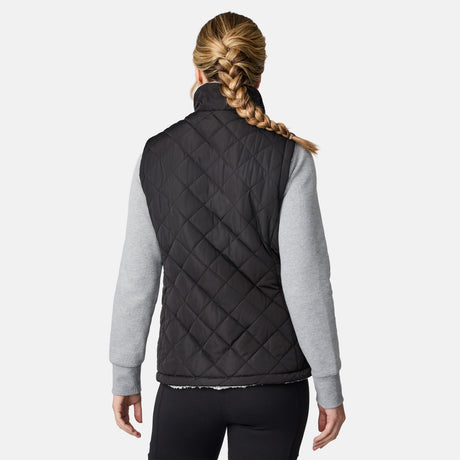 [CJ is 5'10" wearing size S.] Women’s Free Country black quilted vest with zip-front closure and dual zippered pockets—reversible to cozy sherpa for added warmth and versatile styling. Layered over a light gray long-sleeve shirt for a casual, cold-weather look.
